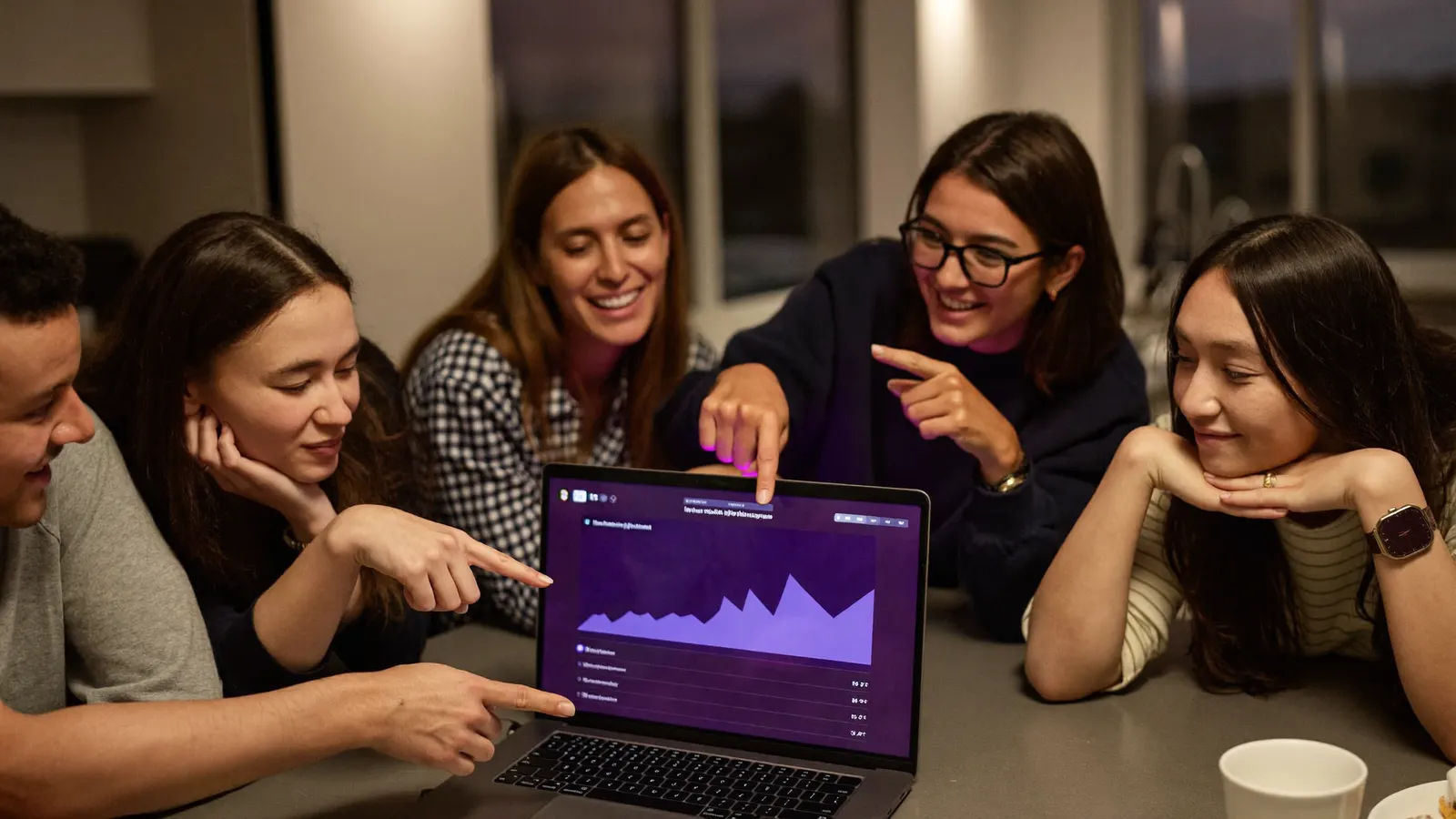Coworkers gathered around a laptop showing a contest leaderboard